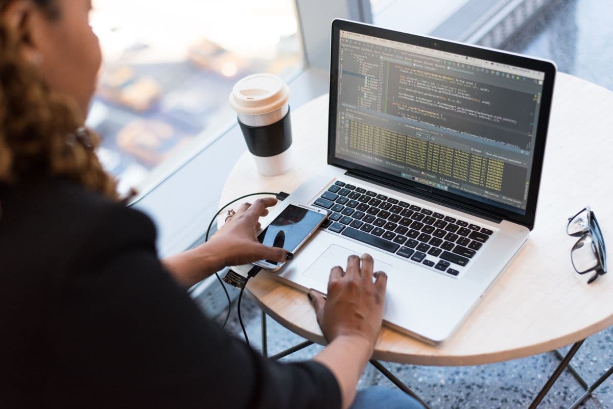Développeuse concentrée devant du code sur son ordinateur portable